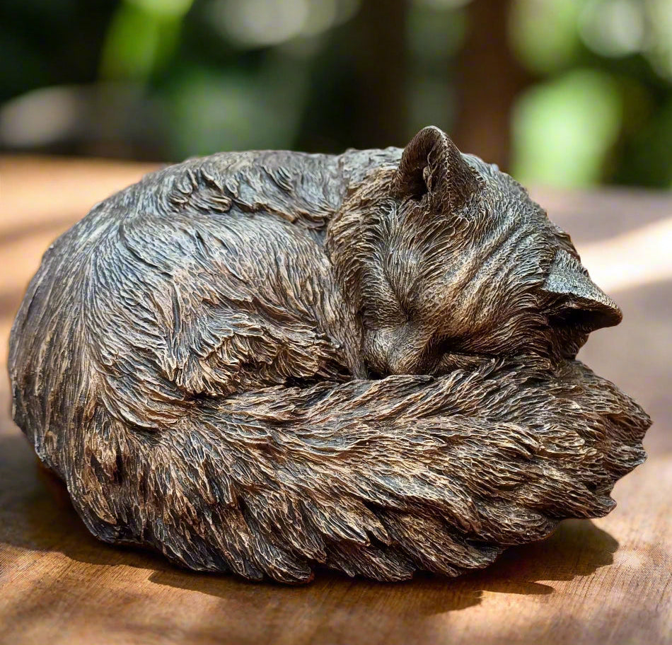 Bronze cat figurine on a wooden surface 