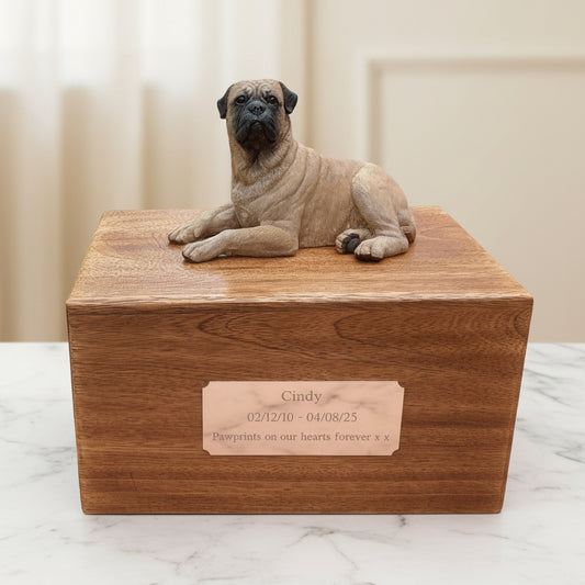 Wooden pet urn with a bullmastiff figurine on top, placed indoors.