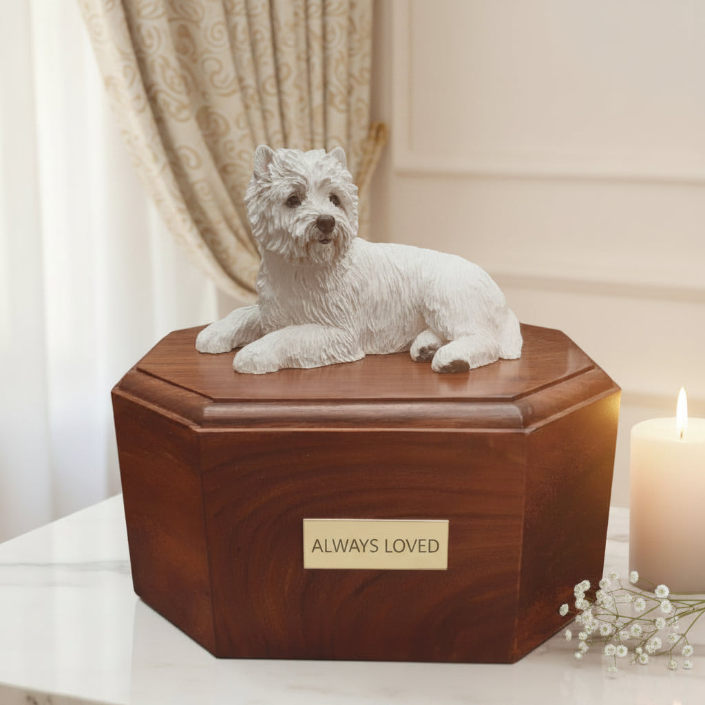 A wooden urn with a solid brass trim and a hand-painted sculpture of a West Highland White Terrier dog lying on top.