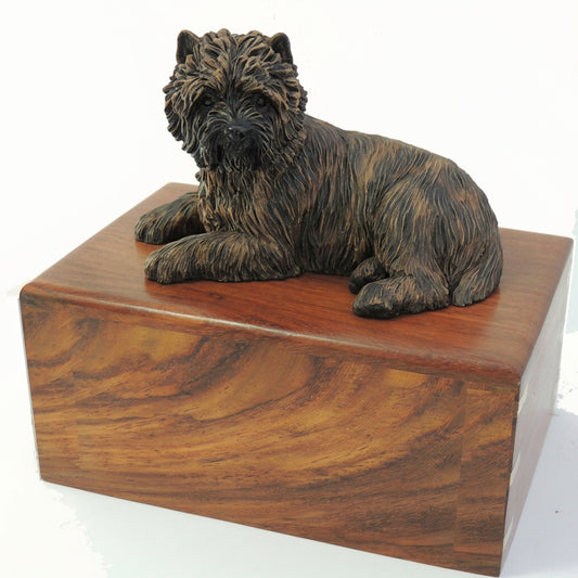 A wooden cremation urn with a sculpture of a cairn terrier dog on top.